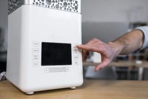 Close up photo. A man's hand that includes a desktop humidifier or air conditioner